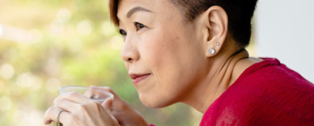 An older asian woman holding a cup