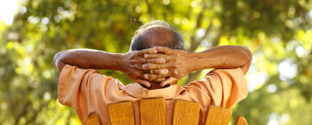 A man sitting on a lawn chair with his hands behind his head