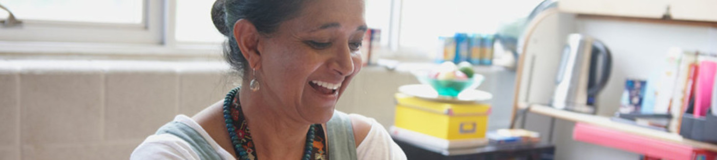 A teacher smiling in a classroom.