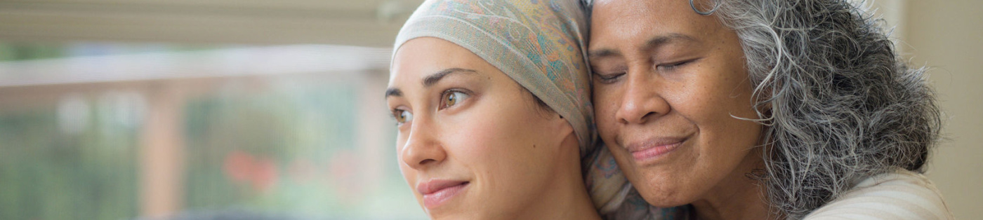 Mother hugs her adult daughter with cancer