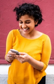 Woman smiling while looking at cell phone
