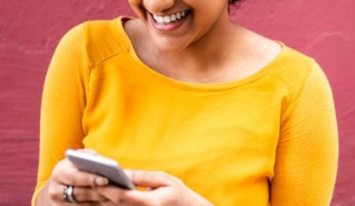 Woman smiling while looking at cell phone