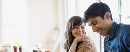 Couple eating breakfast while looking at a tablet