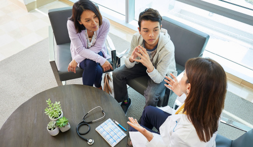 Mother and son listening to a doctor speak with interest 