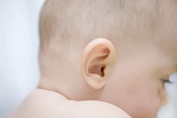 El bebé escucha ponerle una mano en la oreja.