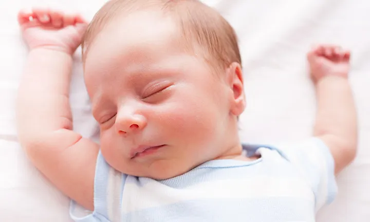 Bebé recién nacido con una diadema en la cabeza acostado sobre una manta  bebé recién nacido soñoliento