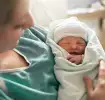 mujer después del parto natural, sosteniendo a un bebé recién nacido