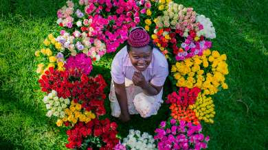 A woman sitting in a circle of flowers