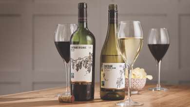 Two bottles of Co-op Fairtrade wine, one red and one white, poured into three glasses.