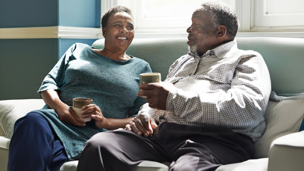 Two people sat chatting and having a coffee.