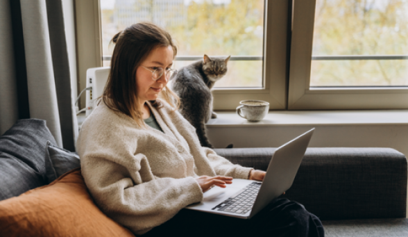 Woman using laptop with cat