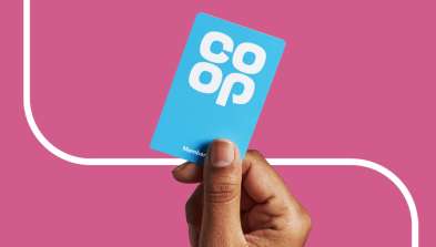 A hand holding a blue card with the word coop on it