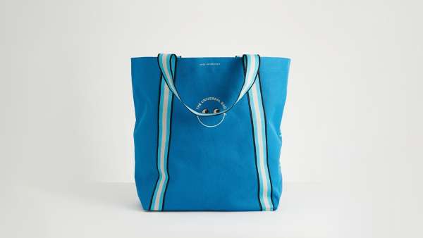 The Universal Bag by Anya Hindmarch, in blue with white and blue handles and a logo to the side.