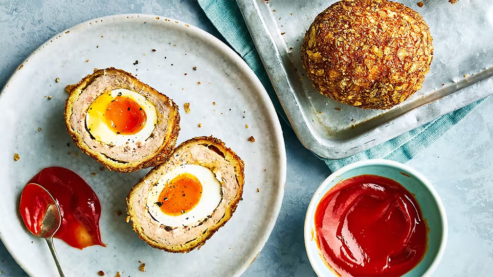 A plate of food with eggs and ketchup on it