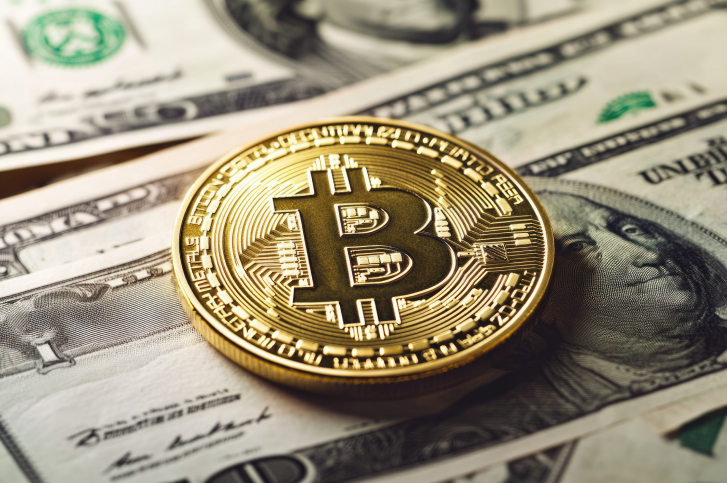 moeda de bitcoin sobre nota de dolar