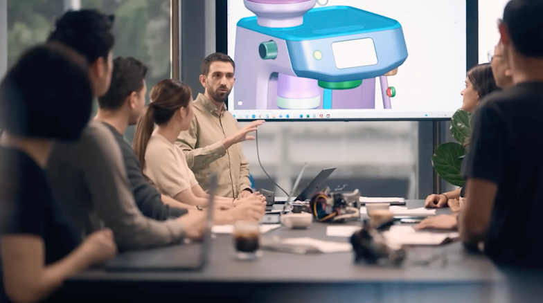 Business meeting with presenter pointing at screen showing colorful medical or scientific device design.