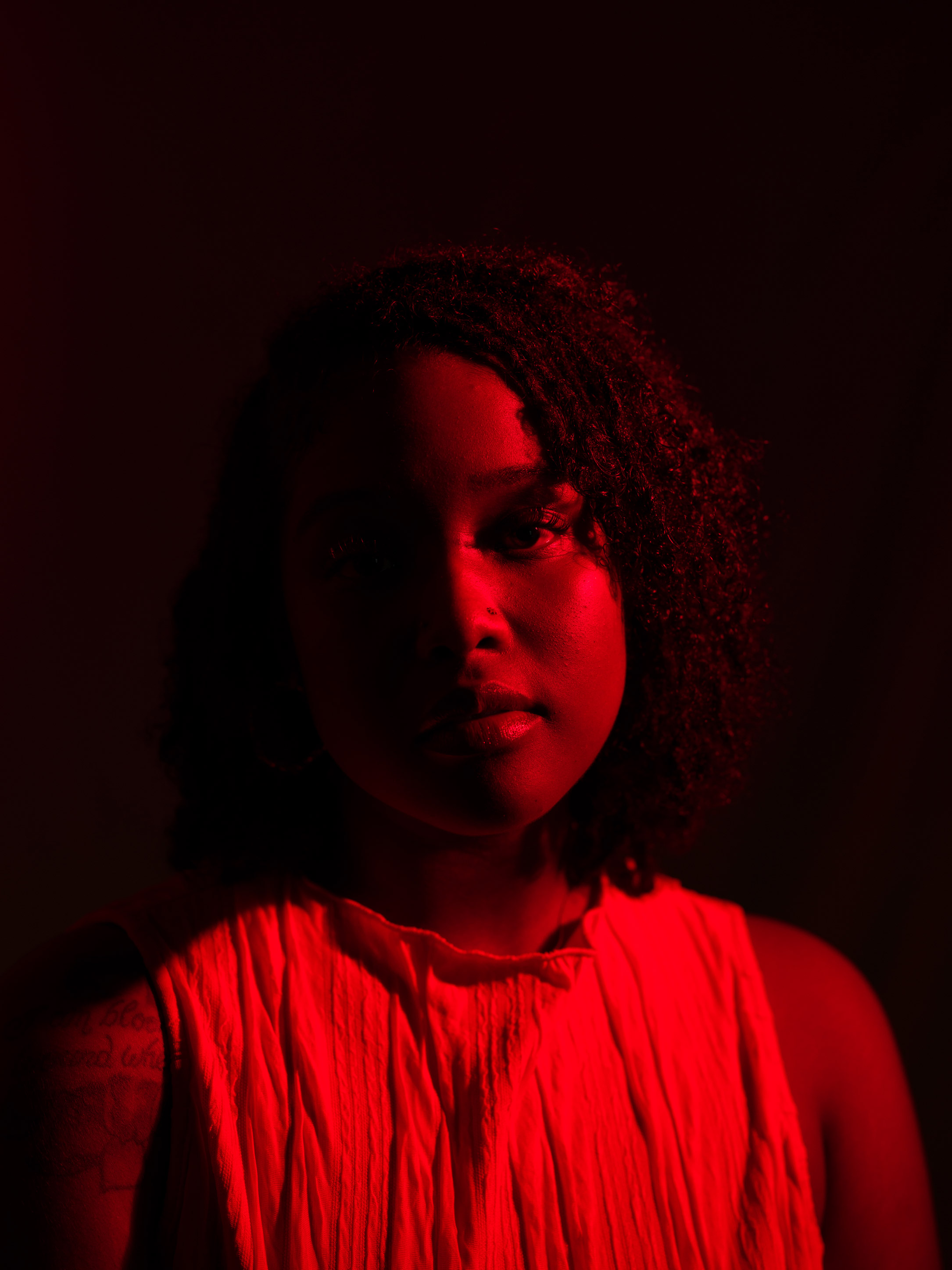 Portret van een persoon met rood licht met gebruik van splitverlichtingtechniek door Kaylah Sambo op een Hasselblad X1D-50c