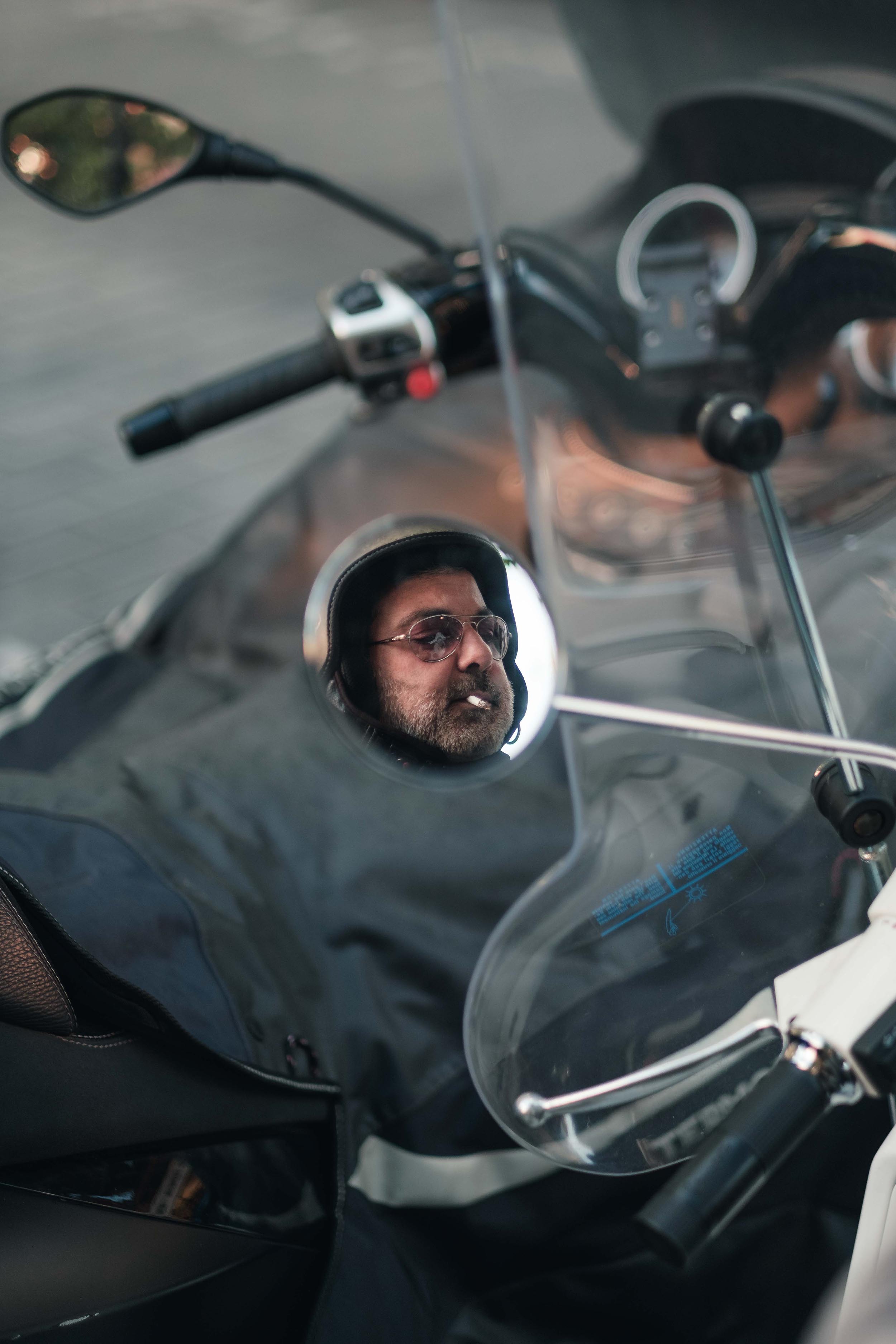Spiegelbeeld van een rokende man op een motorfiets