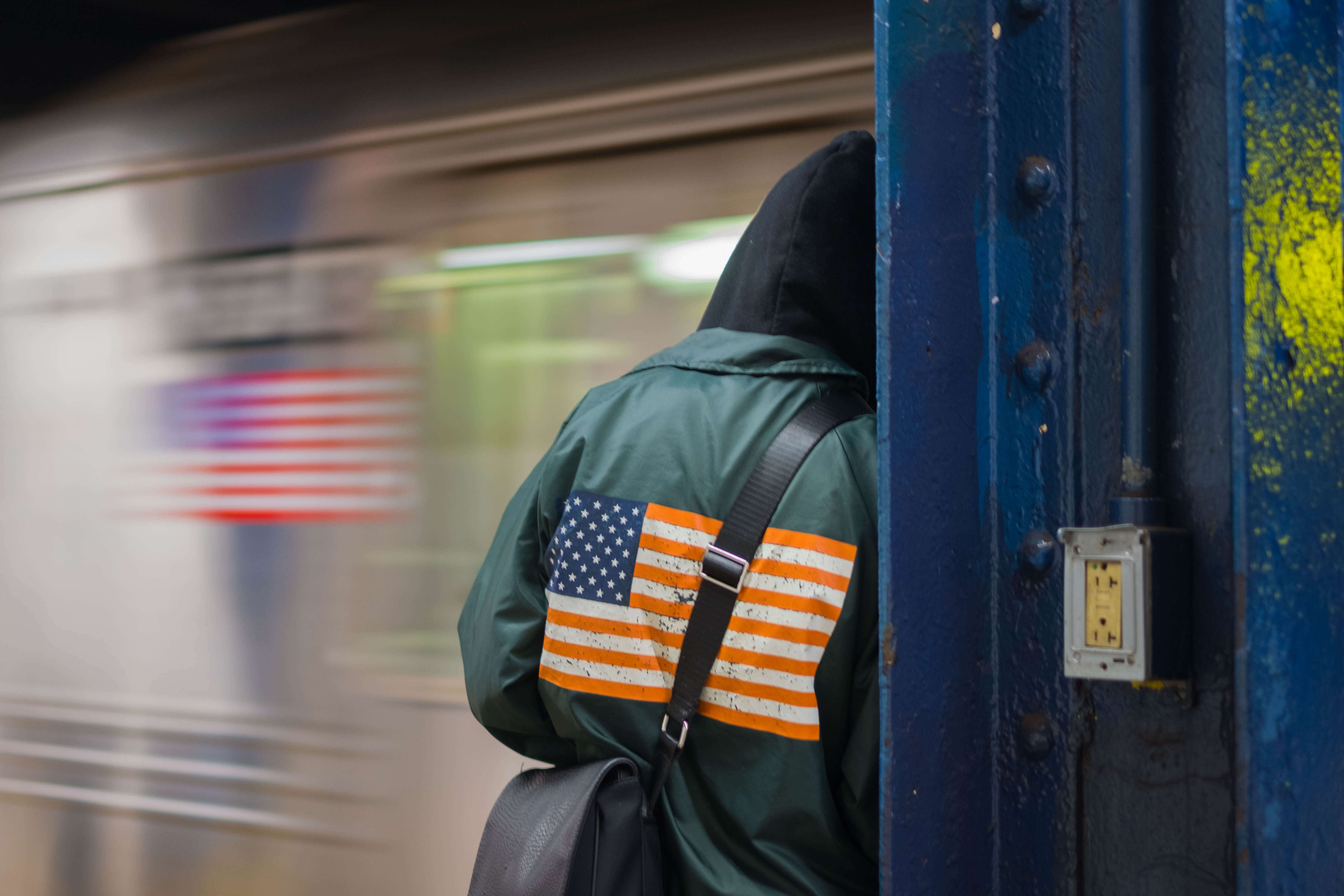 Person with a USA flag motif in front of train with the same motif