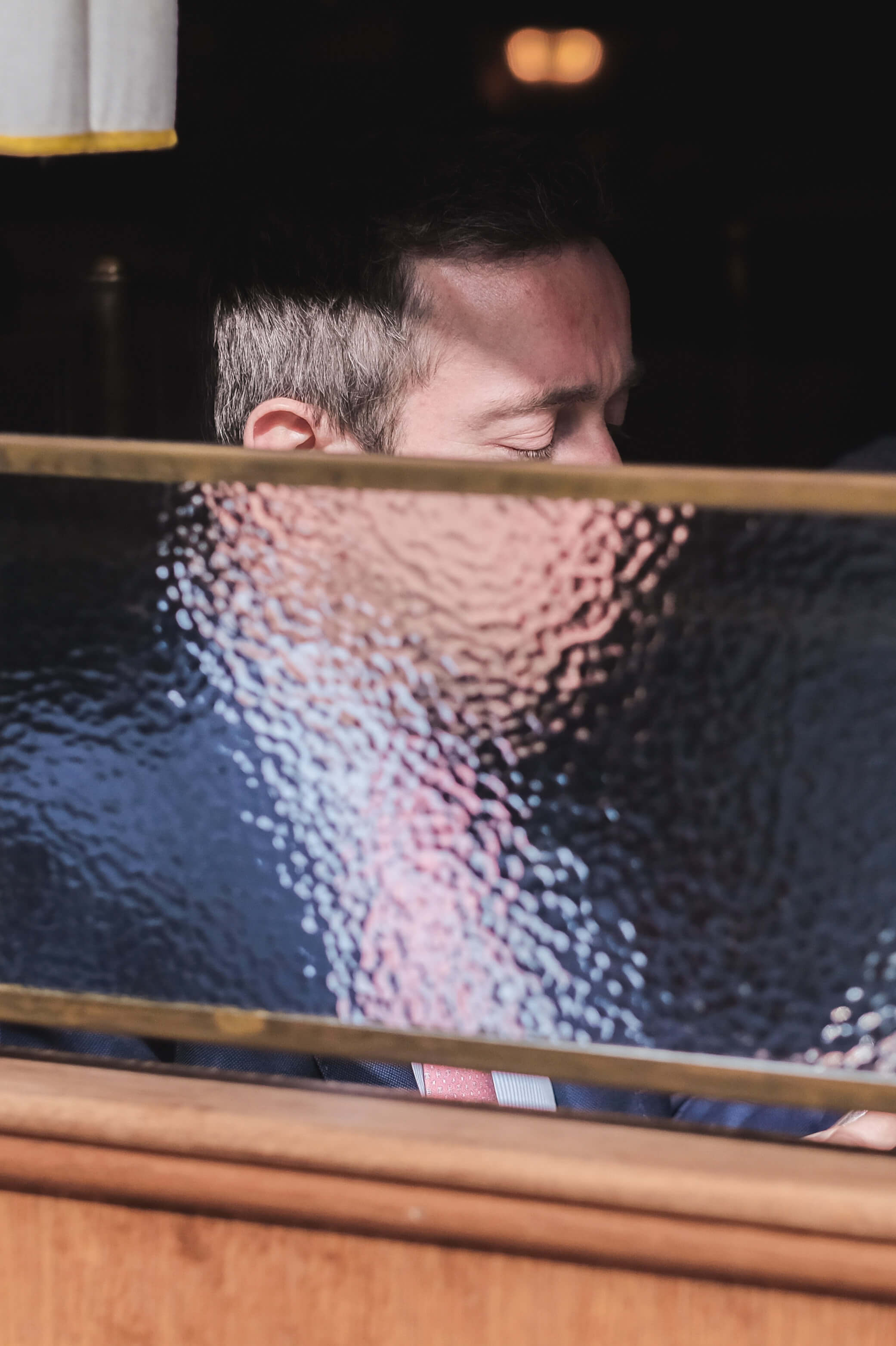 Person half obscured behind frosted glass