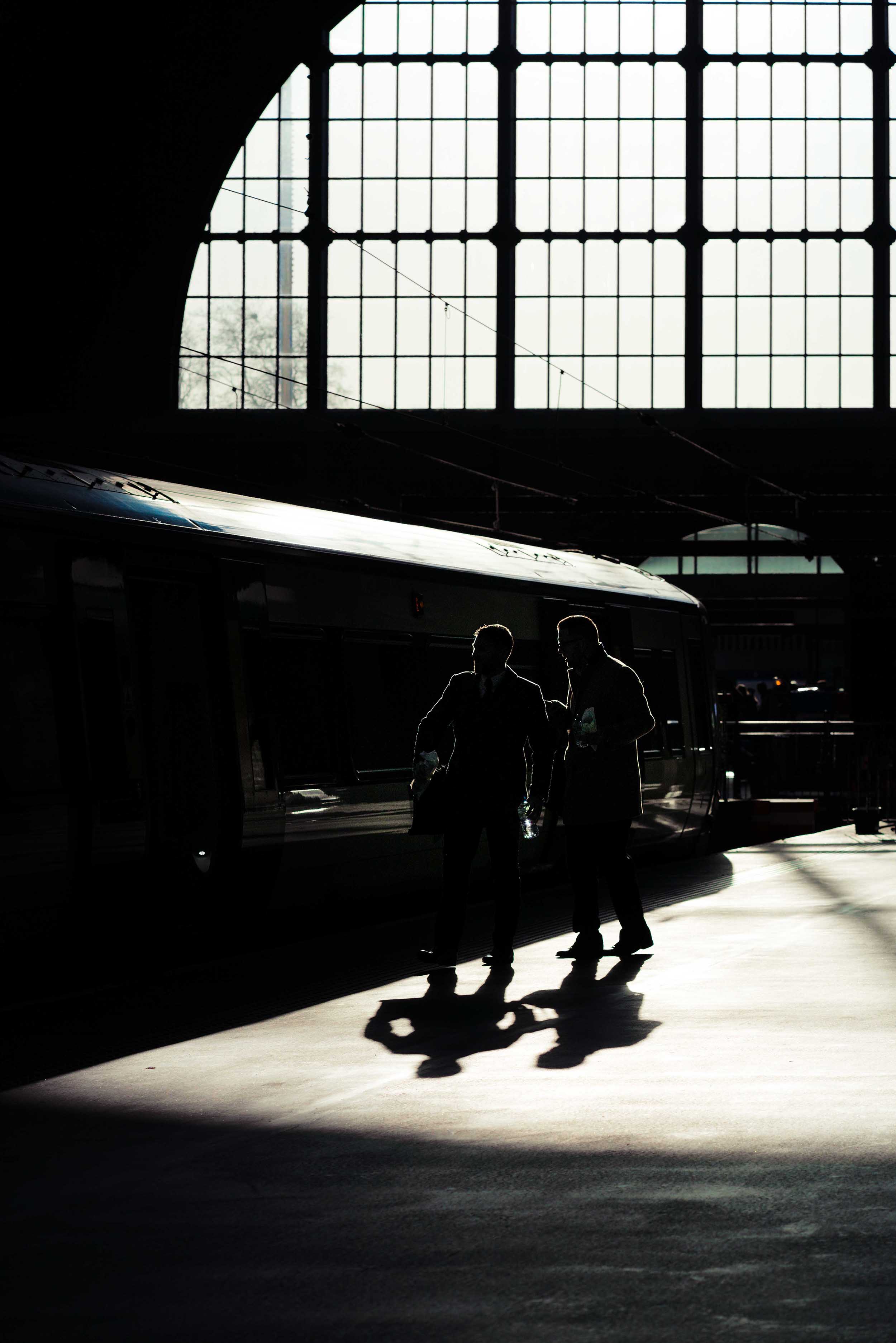 Two people silhouetted in a train station