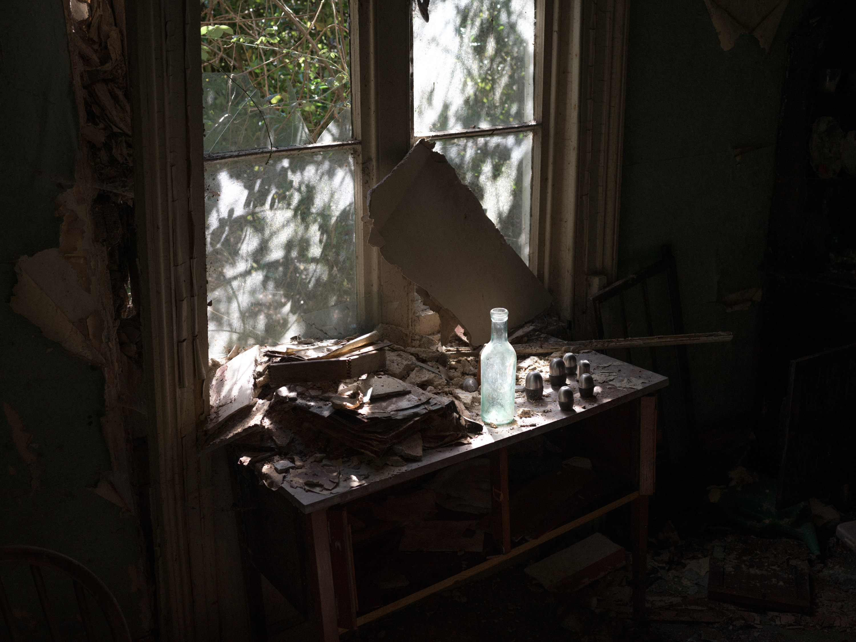Light shining through a window illuminating a clear glass bottle
