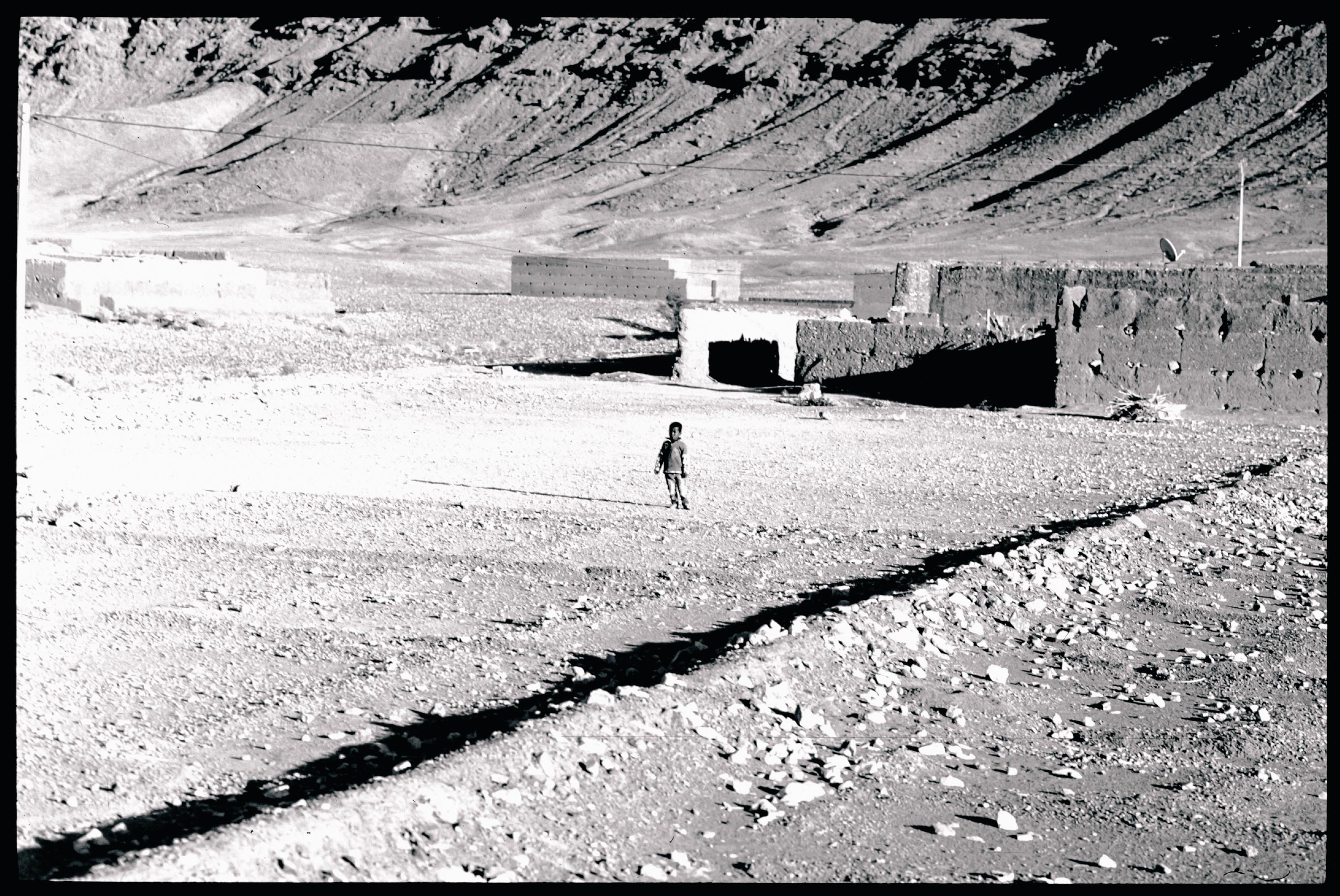Black-and-white photography of a kid in a desert shot on film