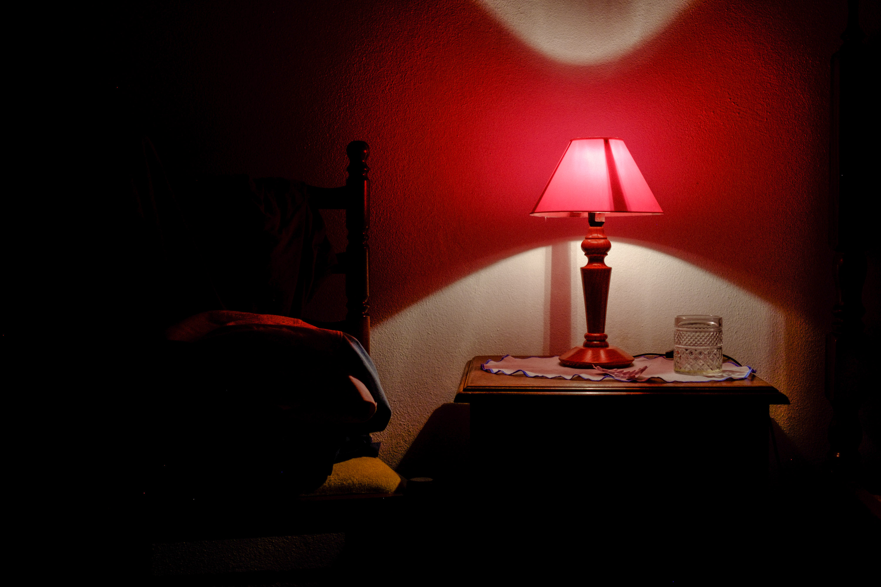 Uma fotografia cinematográfica com um candeeiro e uma cama, foto de Ed Sharp