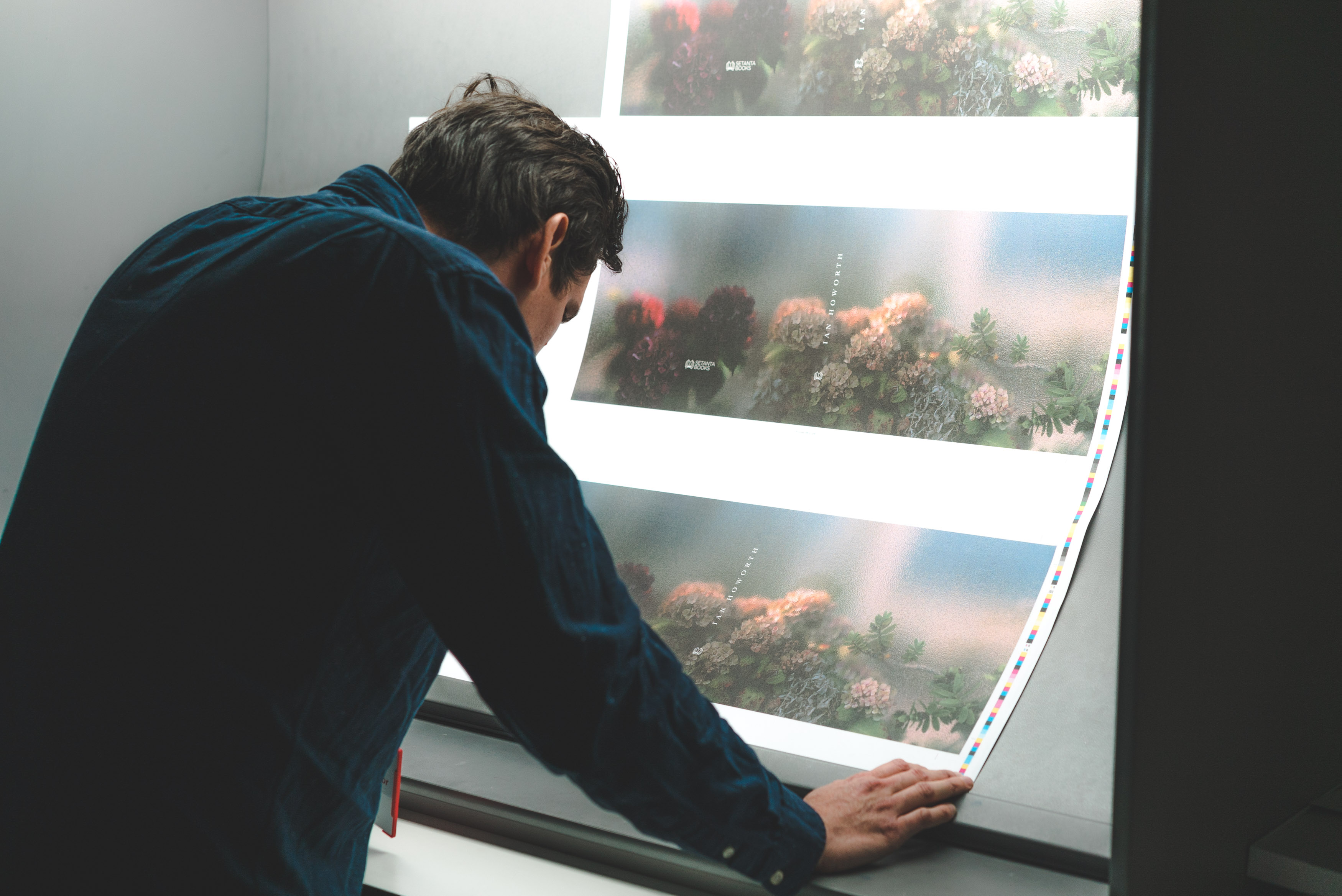 A very attractive man looking at a print