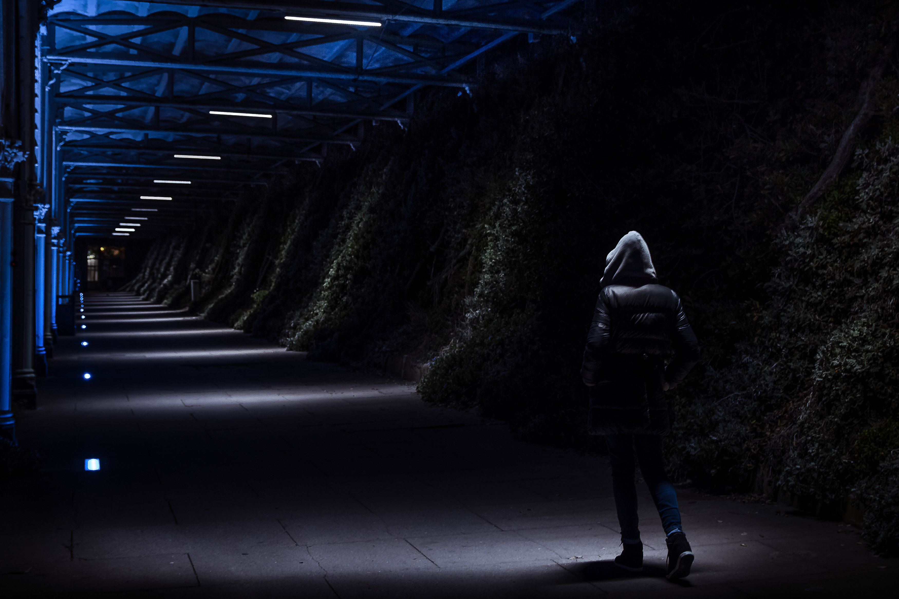 dark photo of hooded person in dark street