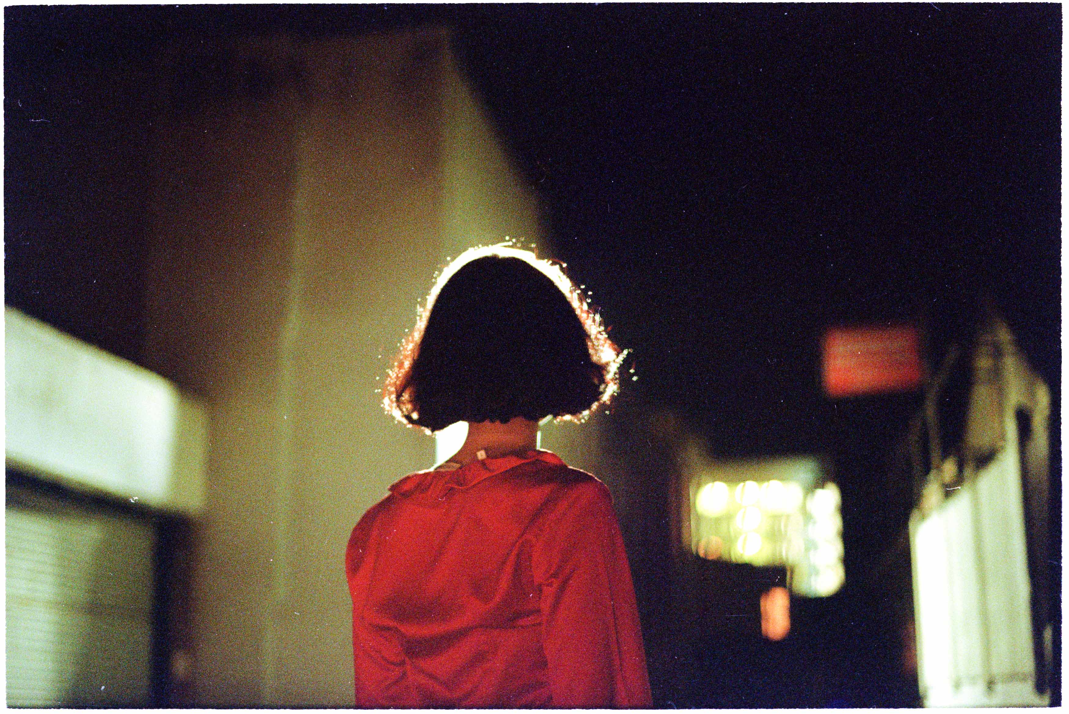 A woman in red in front of a bright light
