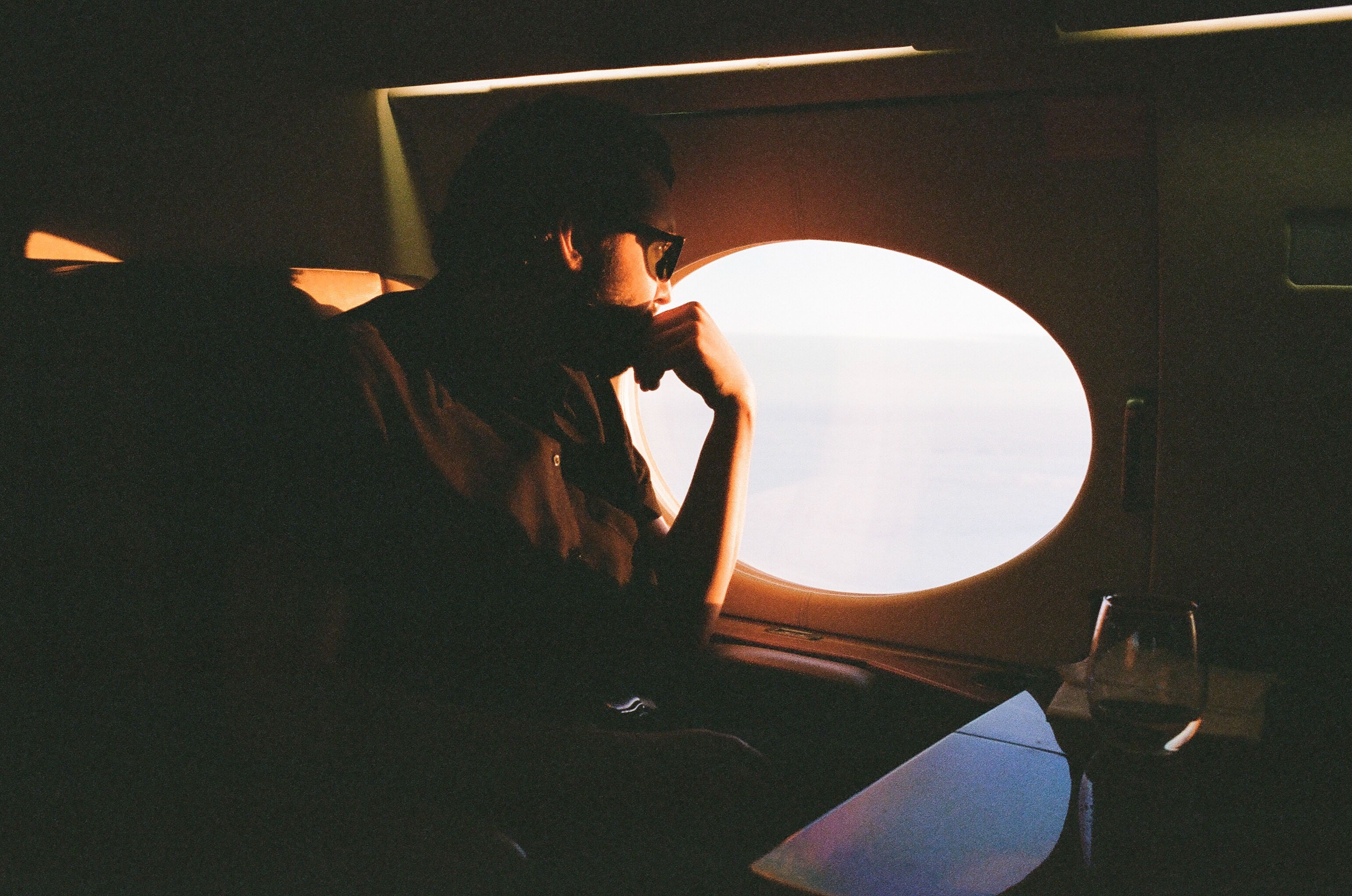 Une personne qui regarde par le hublot d'un avion. Photographié par Matt Helders, batteur des Arctic Monkeys.