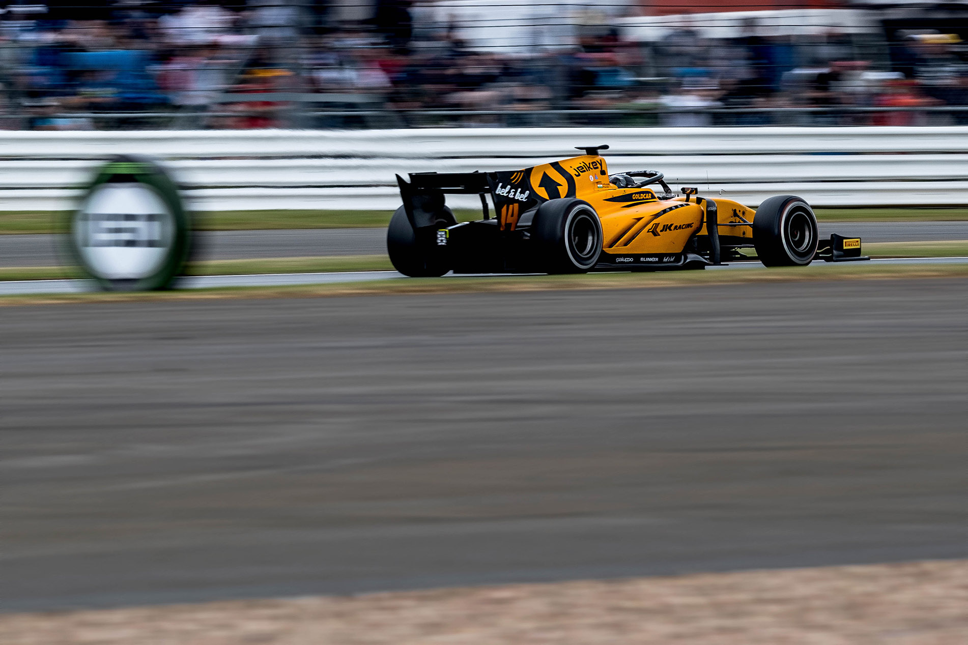 a black and and orange rac ecar with motion blur