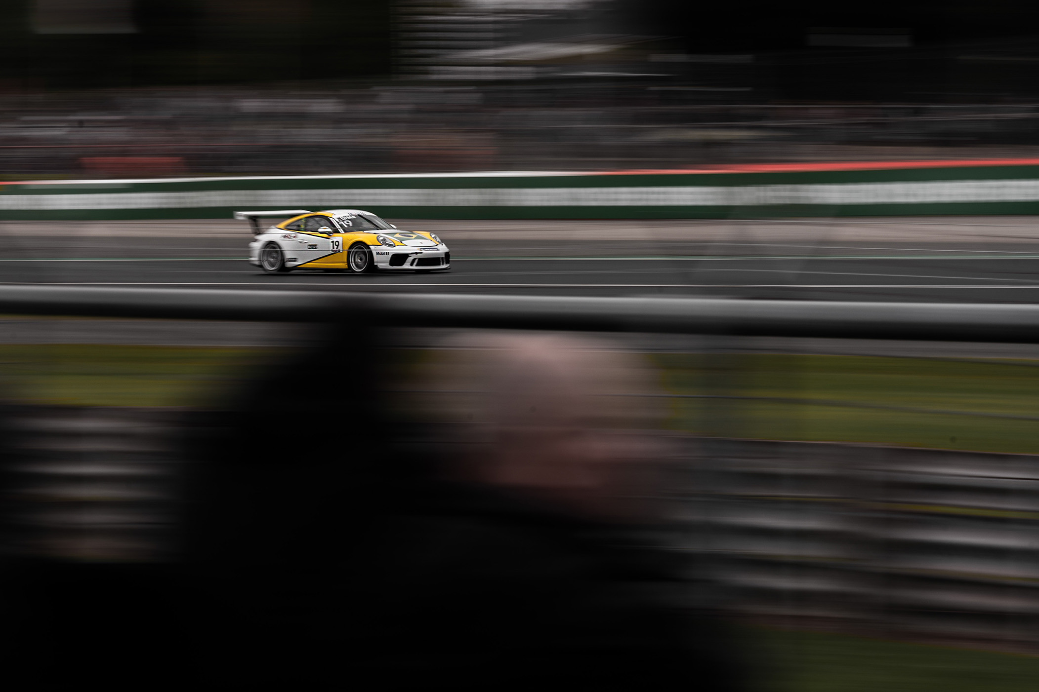 A white and orange race car with motion blur