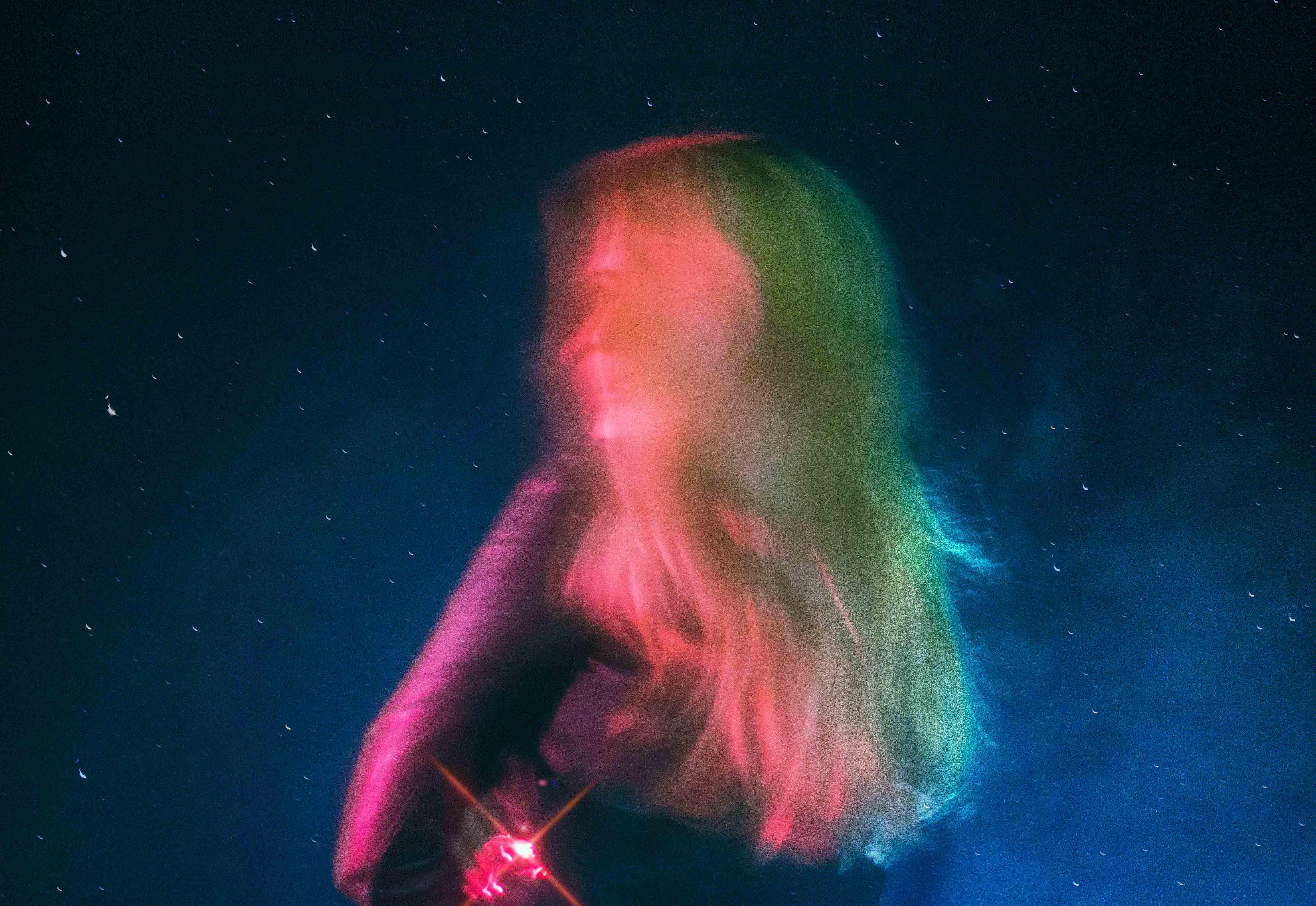A purposely blurry side portrait of a woman in studio lighting.