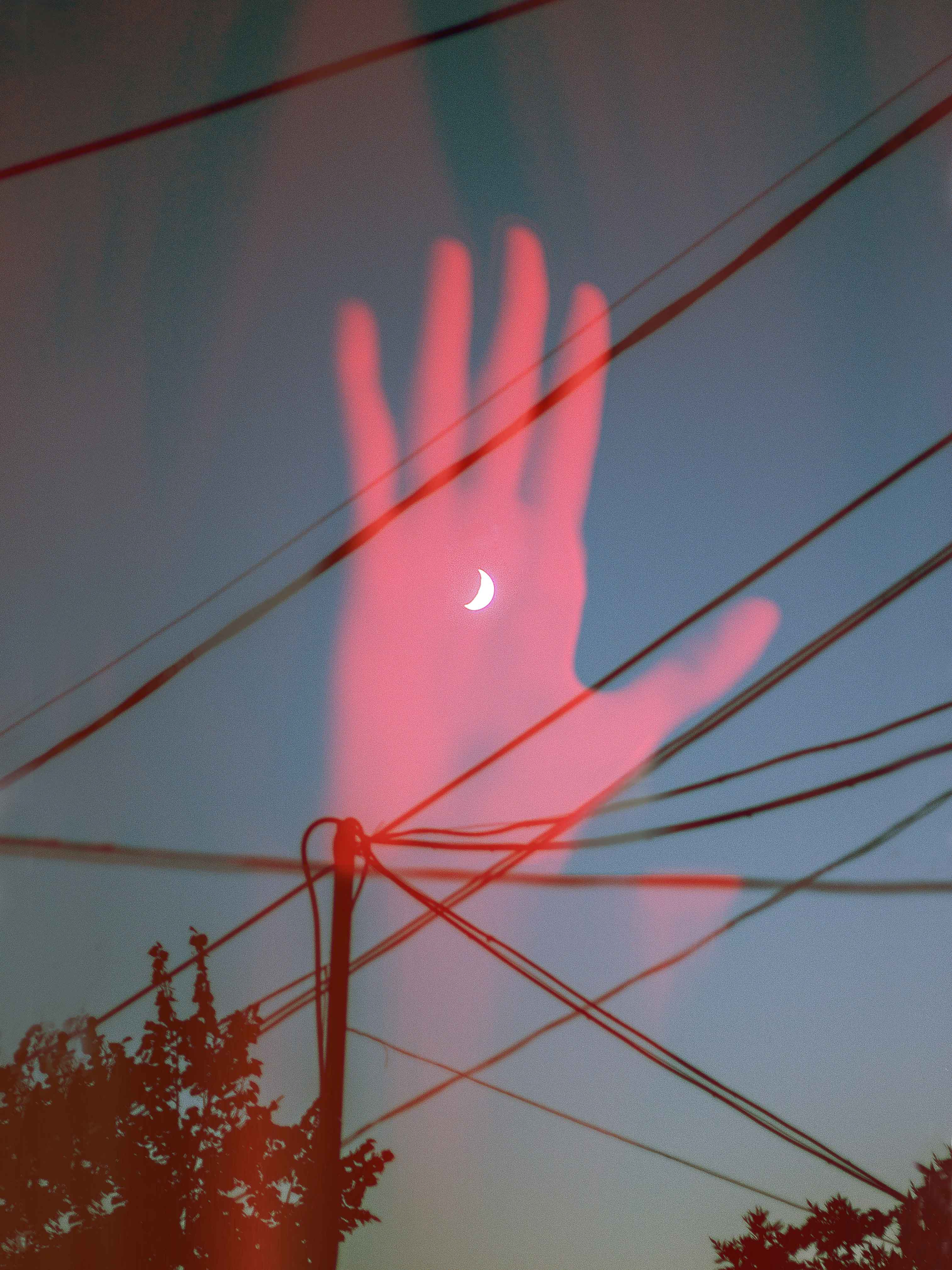 A double exposure of the moon resting in a palm of a hand.