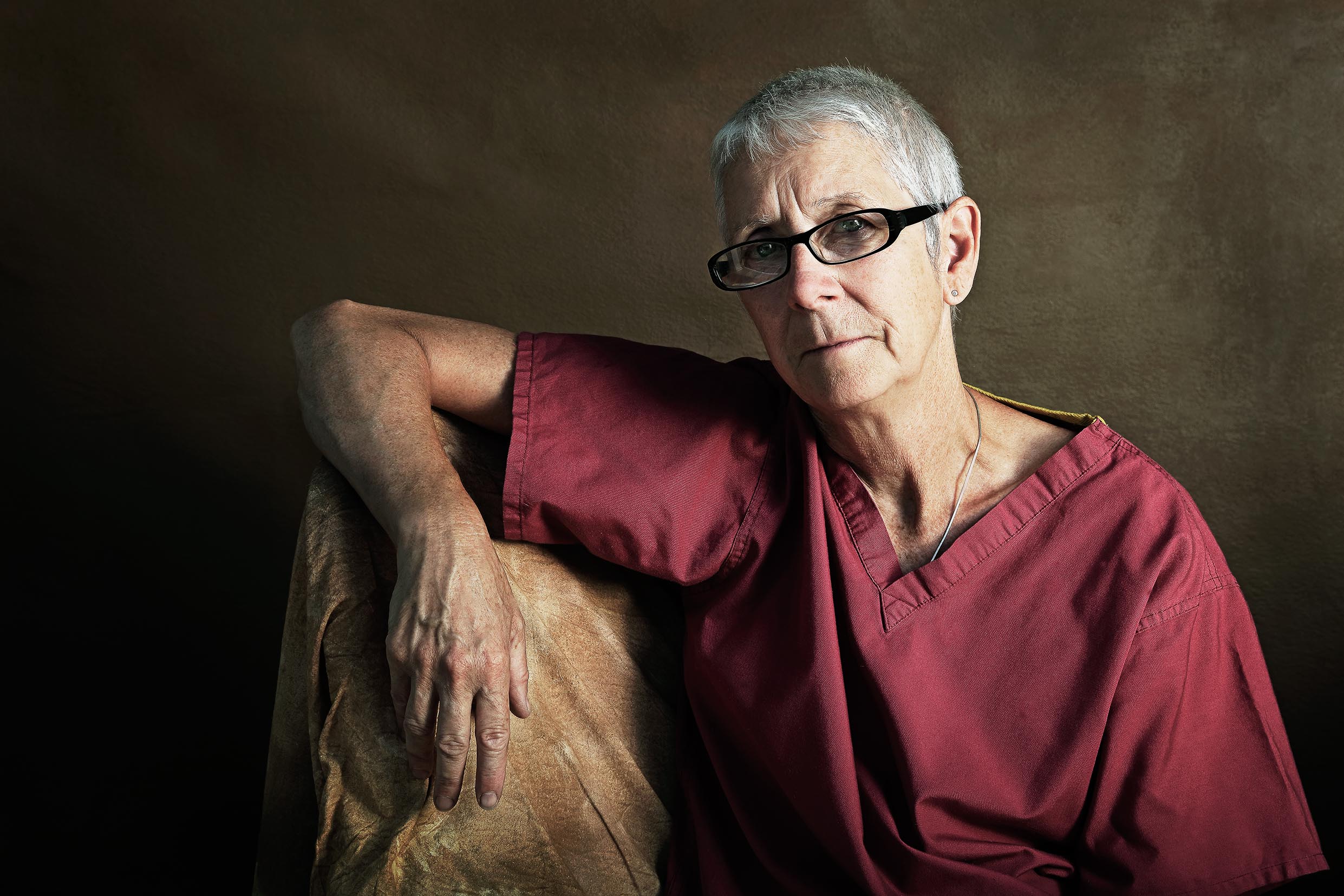 Colour portrait photograph of a hospital worker in a maroon shirt