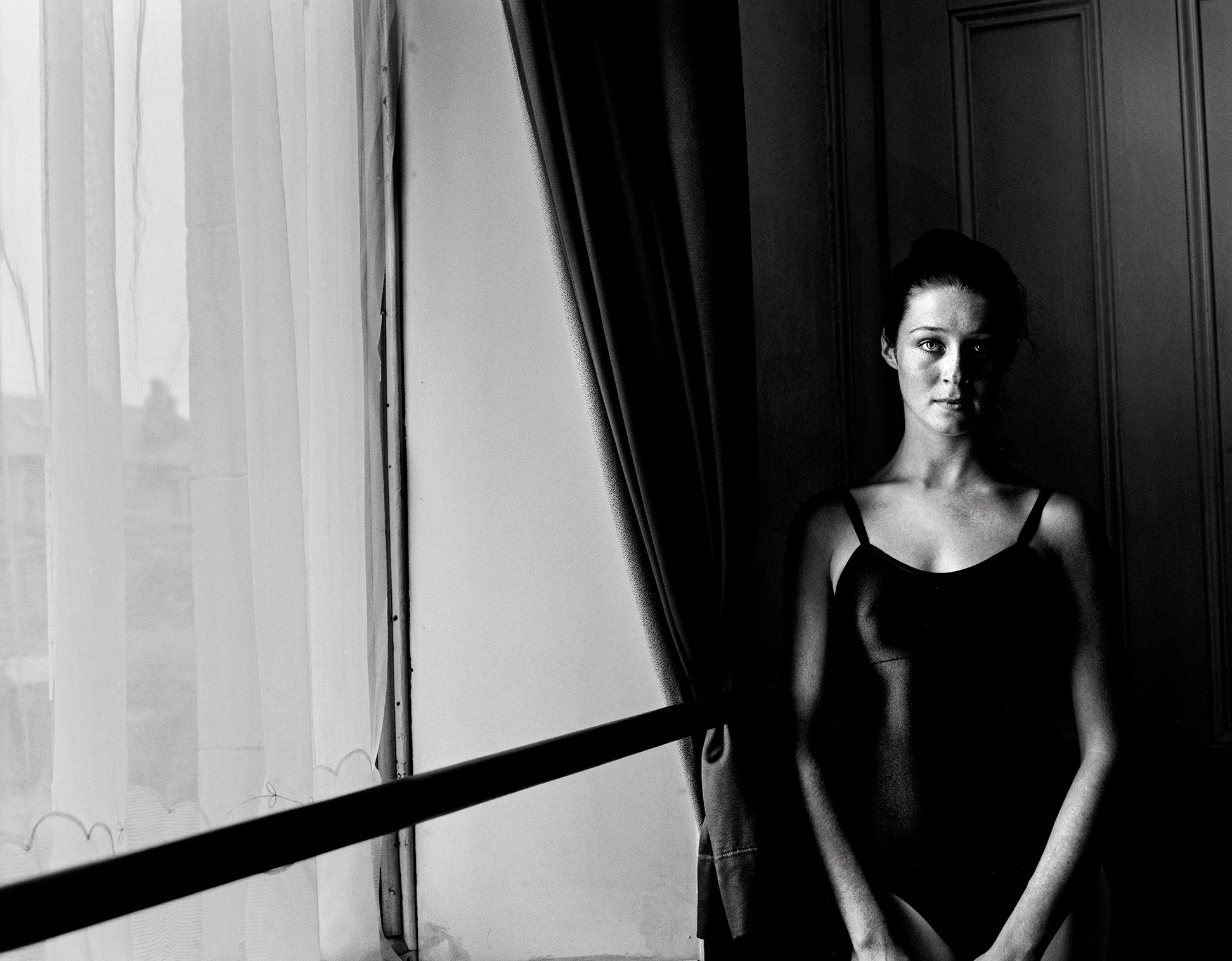 Black and white portrait by a window