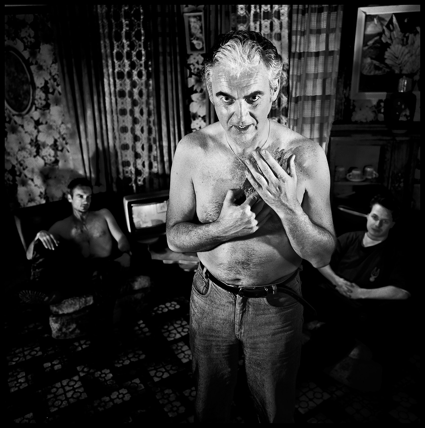 Black-and-white photo of gangsters, one with his hands to his chest