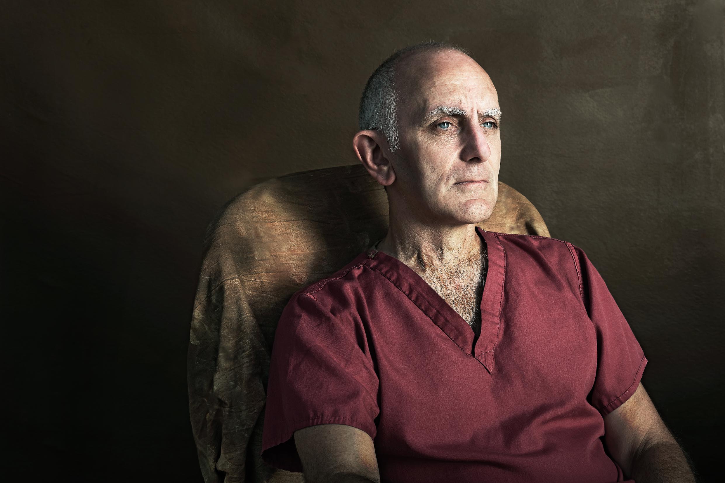 Colour portrait photograph of a hospital worker looking away to the left