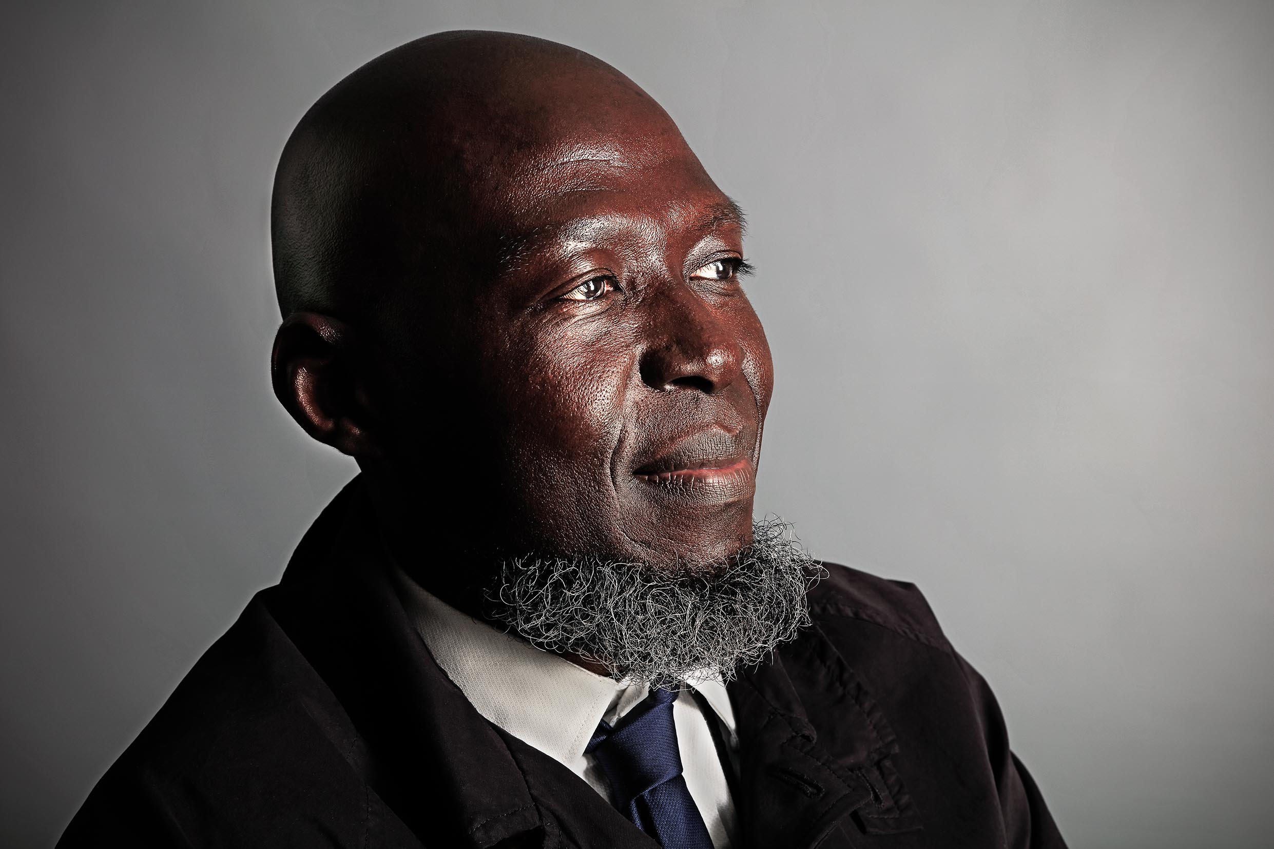Colour portrait photograph of a hospital worker wearing a tie looking away to the right