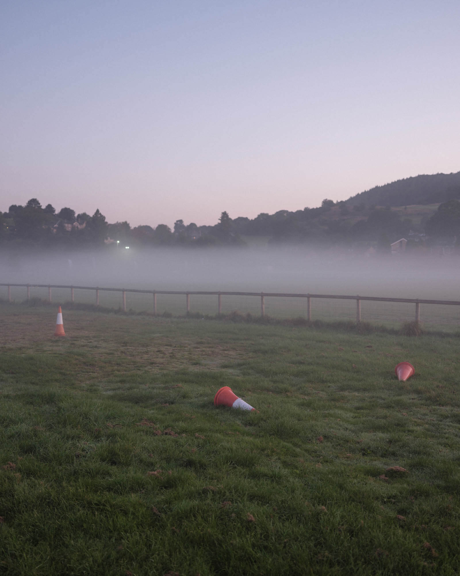 A fence running through a foggy field littered with traffic cones in the Peak District, shot by Tom Illsley with the Fujifilm GFX 50S