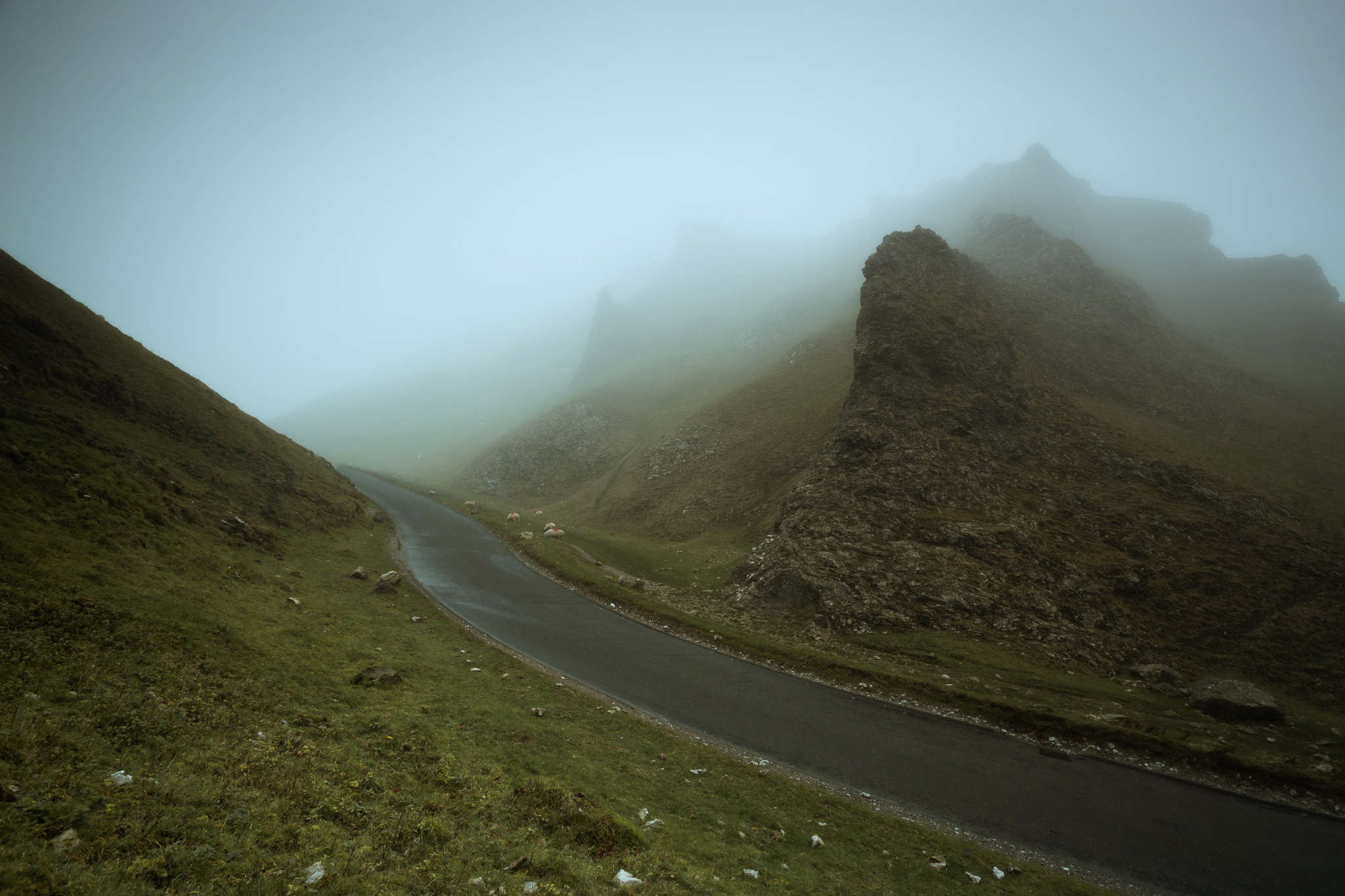 A misty road and hills with rocks
