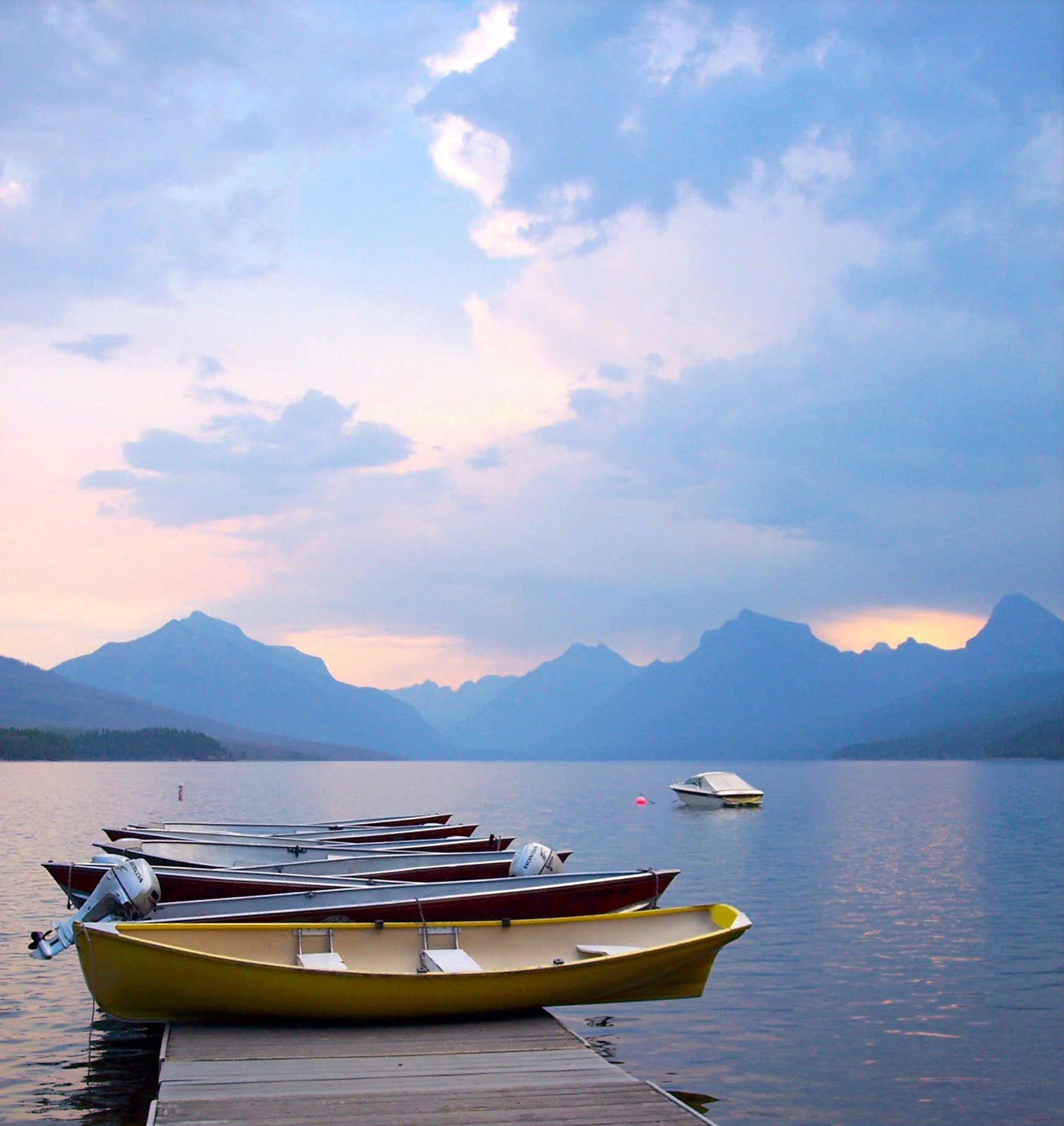 boats on a river with mountains in the back round