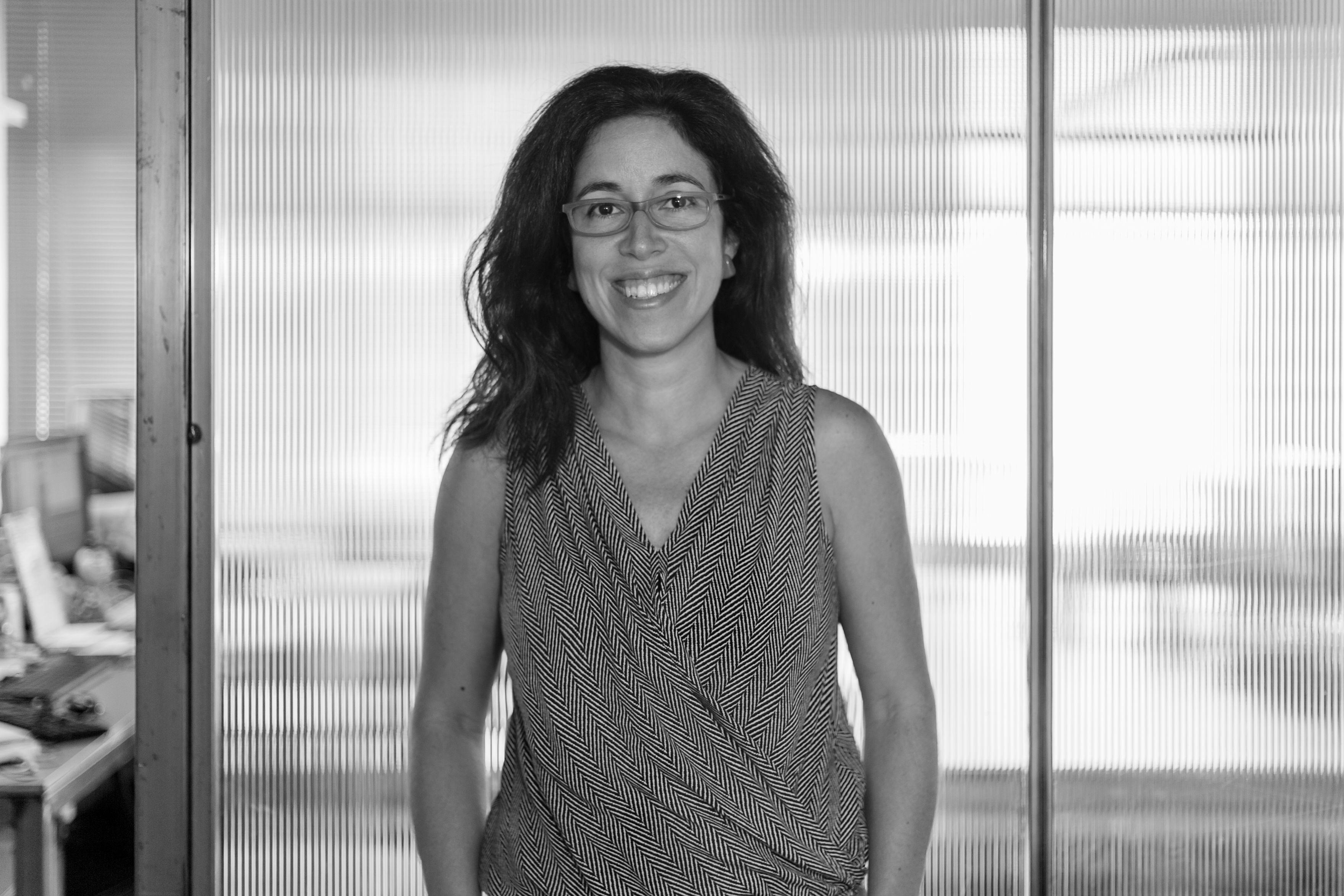 Black & white photo of a lady wearing glasses in an office