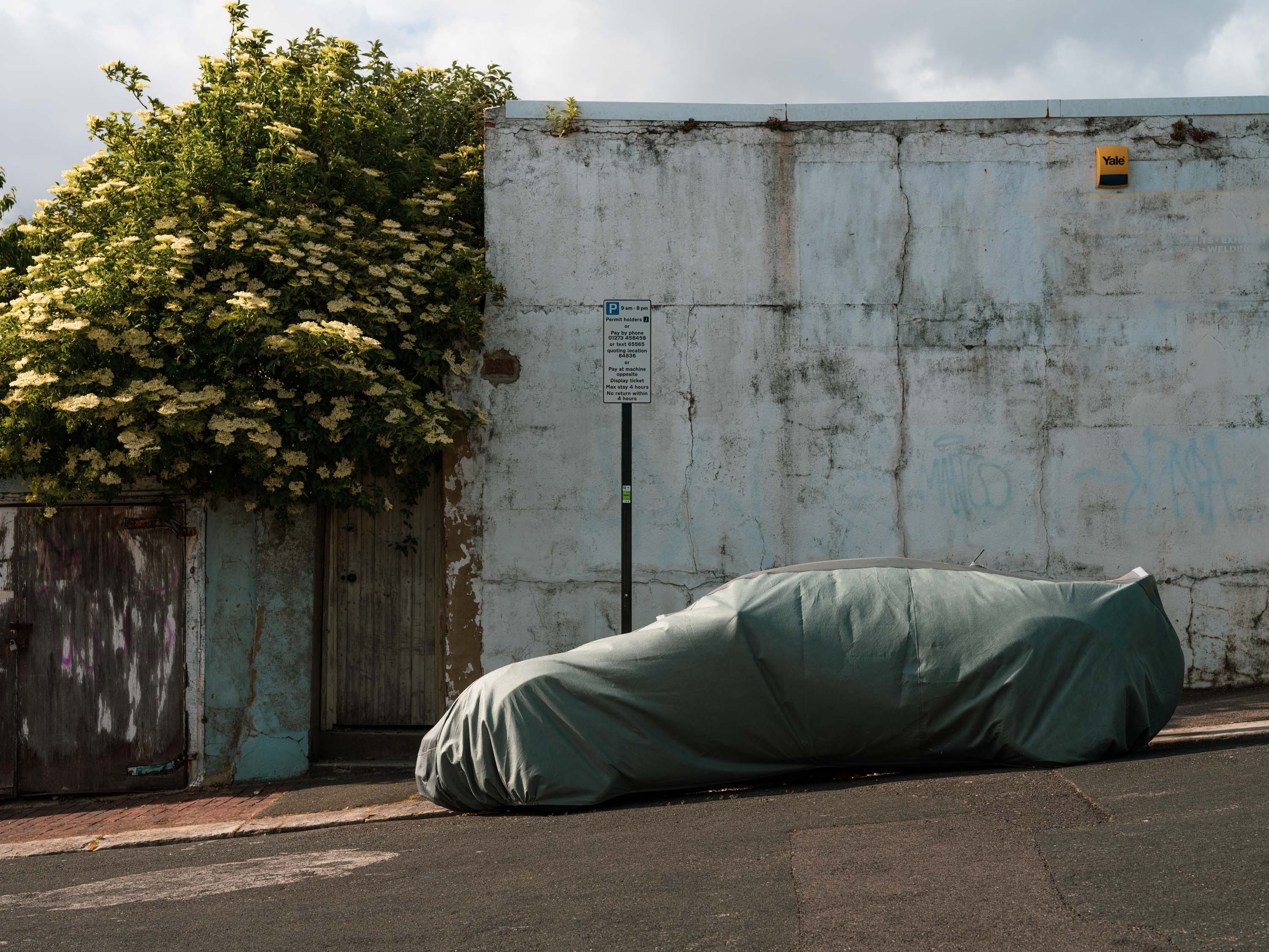 Covered car parked on a sloping street. Shot with Fujifilm GFX100.
