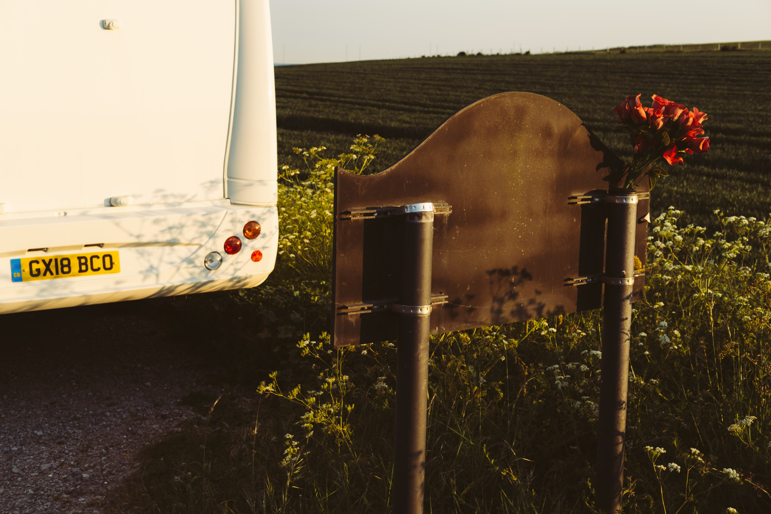 The back of a road sign with a bouquet of roses put inside the pole
