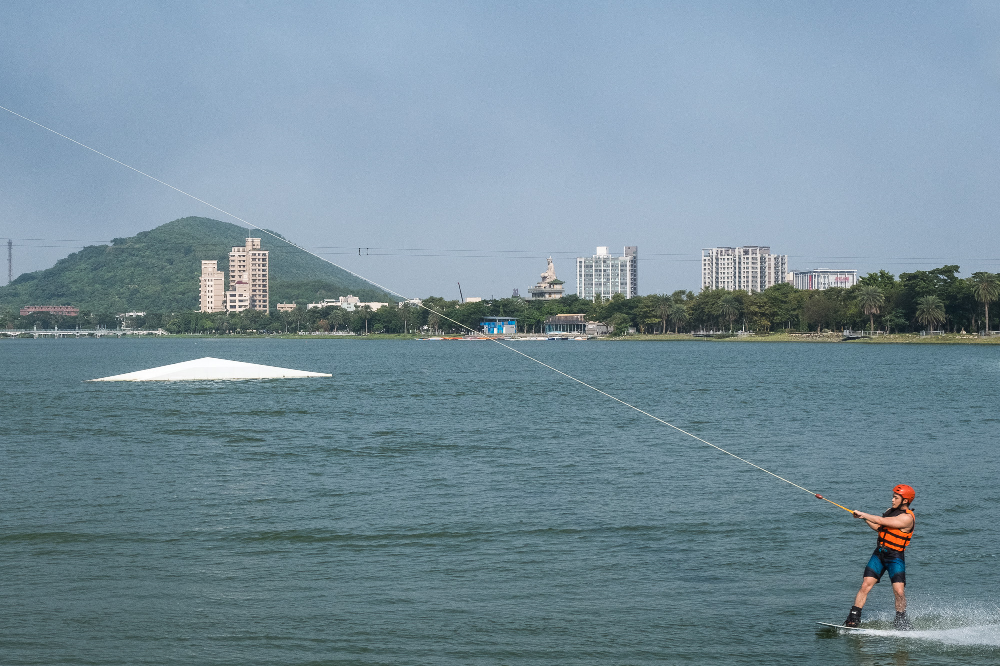 Person beim Windsurfen mit ein paar Gebäuden im Hintergrund