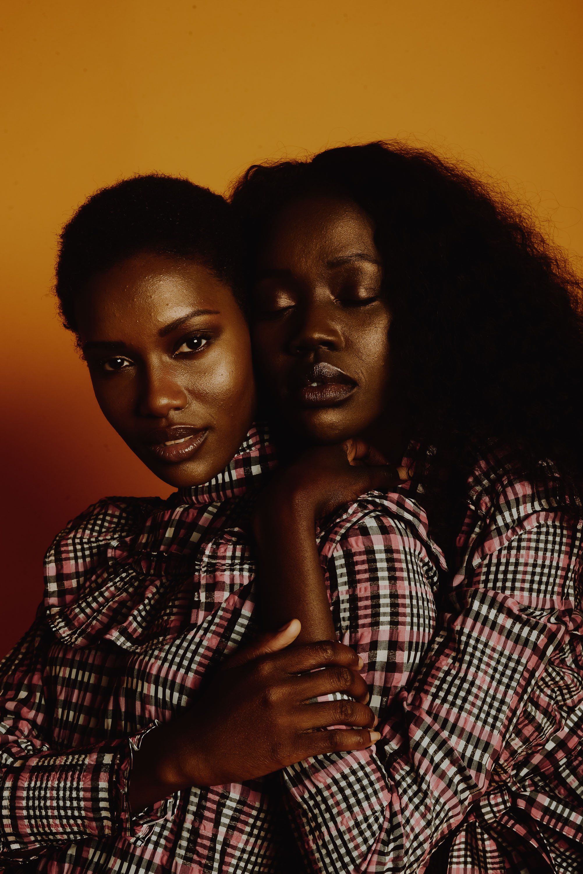 Portrait of two people with orange background