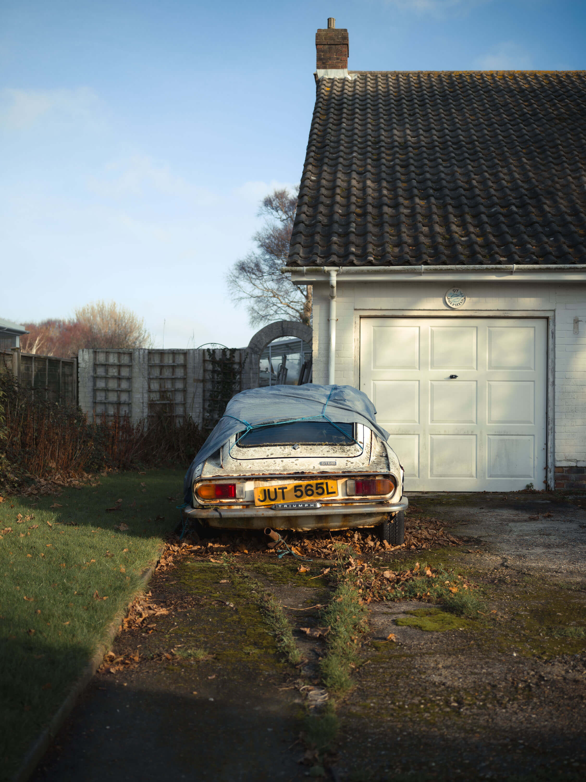 old broken down car outside house